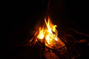 A cheery little campfire brightens the darkness of a night wild camping on the shores of Loch Etive