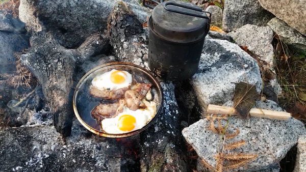 Bacon and eggs on the campfire. And a fish biting...