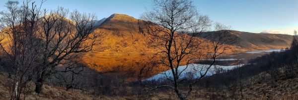 Golden light floods over Ben Starav as the sun starts to set over a mirror like Loch Etive, just after Christmas.