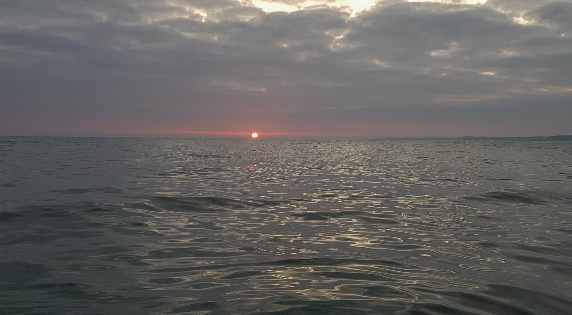 The sun rises over a placid North Sea as we leave St Andrews harbour in mid-November